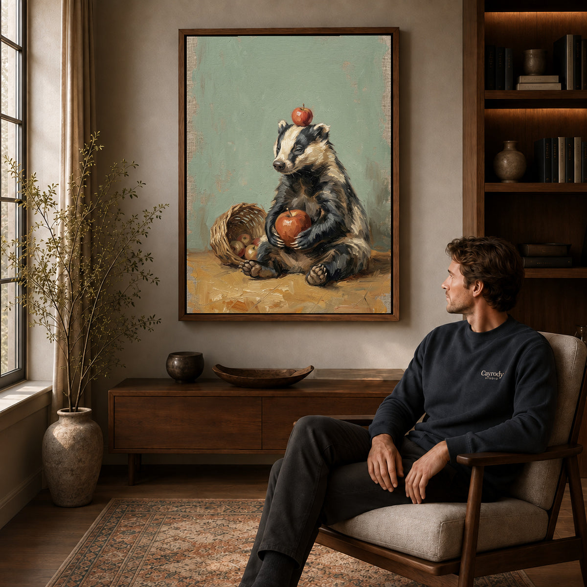 Walnut framed badger apple basket canvas art displayed above a seated man in a wood furnished room.