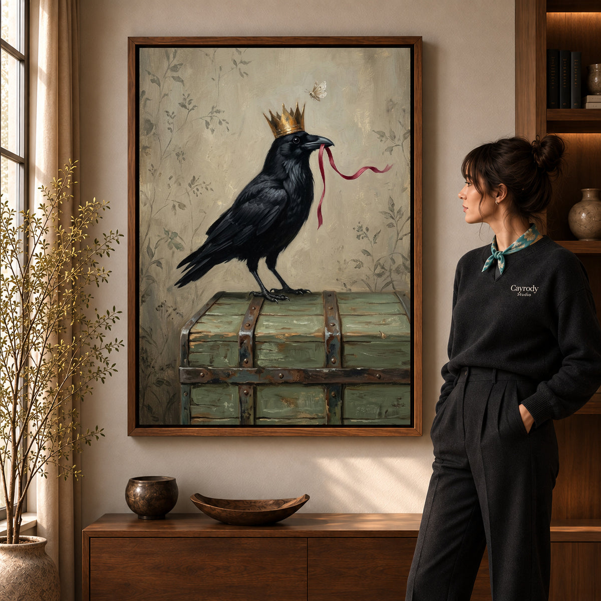 Crowned raven ribbon canvas art in a walnut frame beside a standing woman in a warm living room.