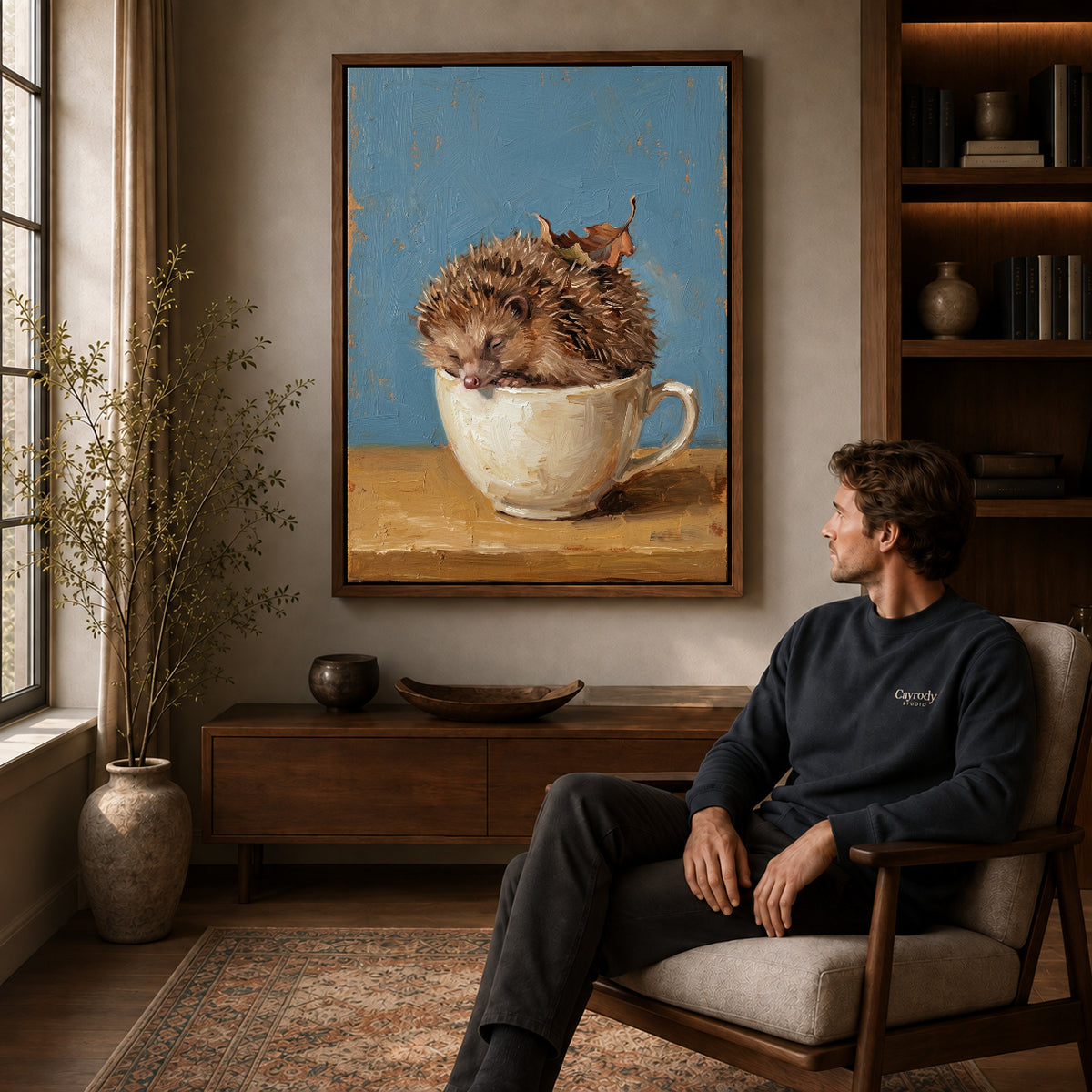 Walnut framed sleepy teacup hedgehog artwork above a seated man in a wood furnished living room.