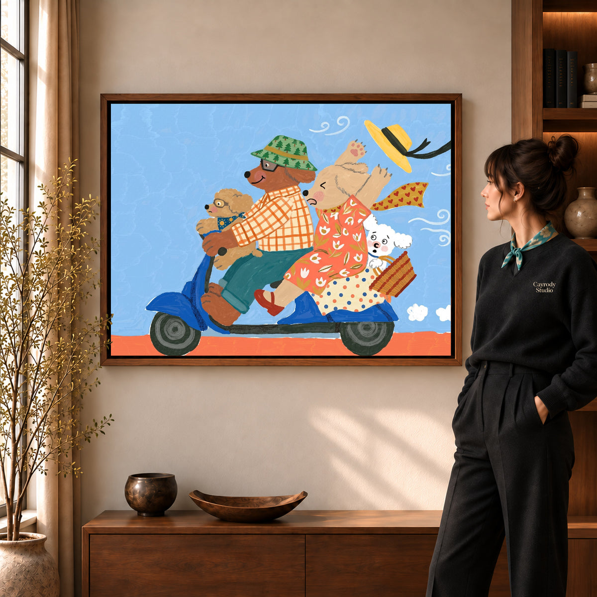 Scooter Dog Family artwork in a walnut frame beside a standing woman in a warm room.