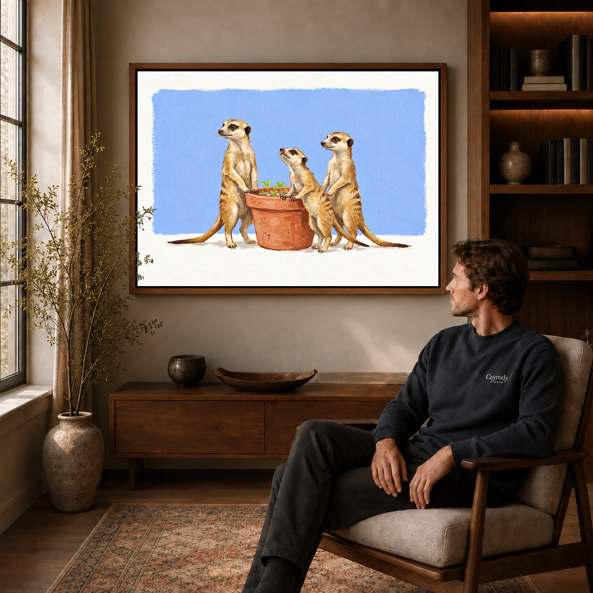 Walnut framed meerkat gardeners artwork above a seated man in a wood furnished living room.