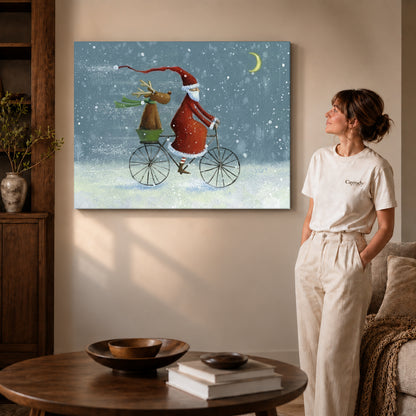 Gallery wrapped santa bicycle ride artwork with shaded canvas edges beside a woman wearing cream clothing.