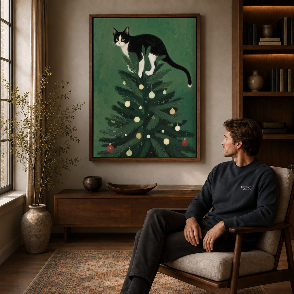 Walnut framed christmas tree kitten artwork above a seated man in a wood furnished living room.