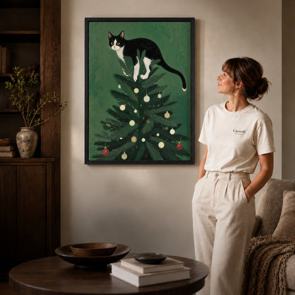 Black framed christmas tree kitten artwork beside a woman in a warm neutral living room.