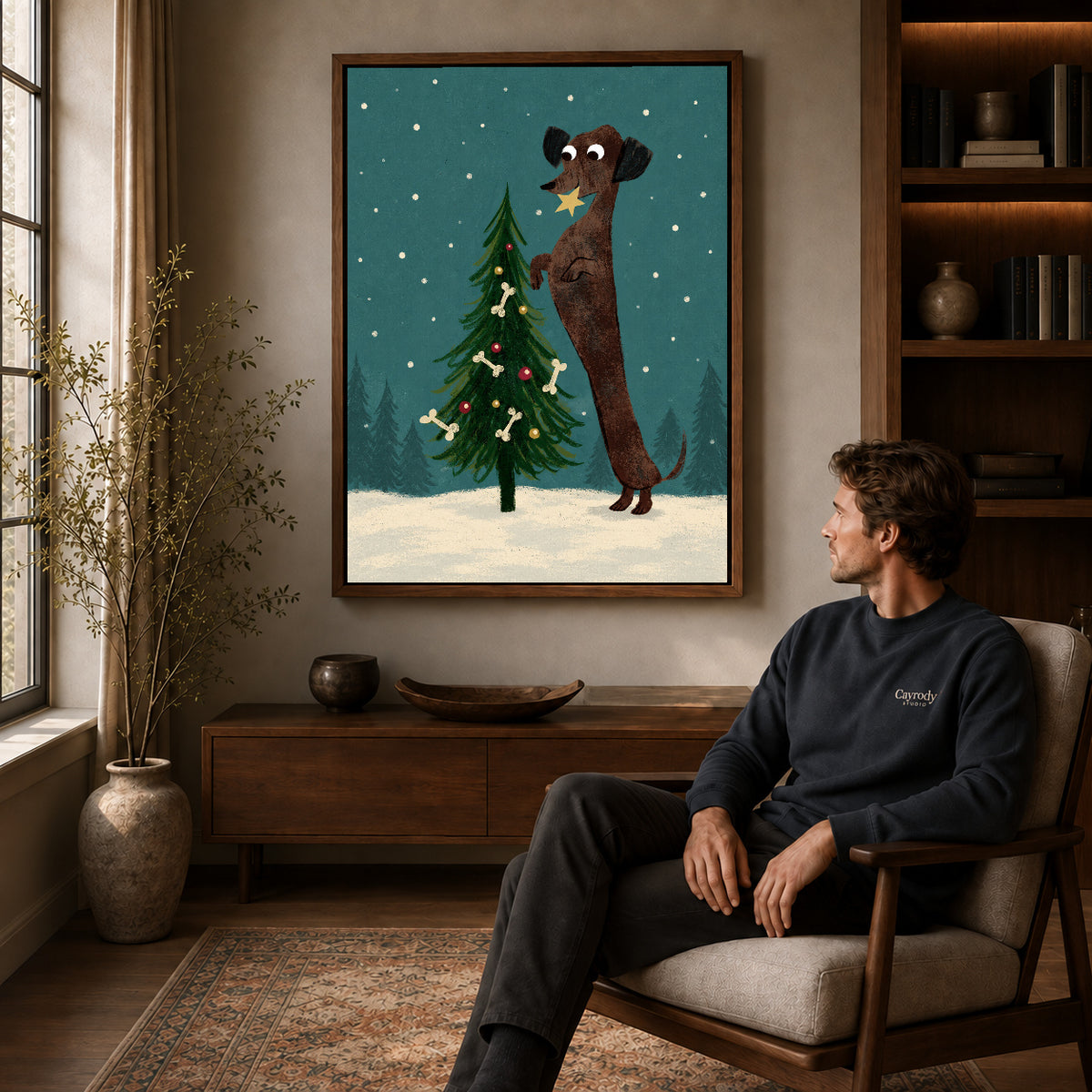 Walnut framed christmas dachshund tree artwork above a seated man in a wood furnished living room.