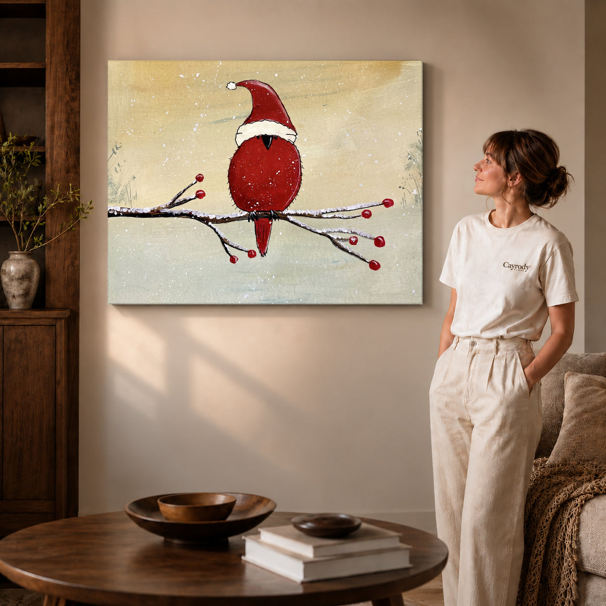 Gallery wrapped christmas cardinal artwork with shaded canvas edges beside a woman wearing cream clothing.
