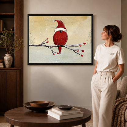 Black framed christmas cardinal artwork beside a woman in a warm neutral living room.