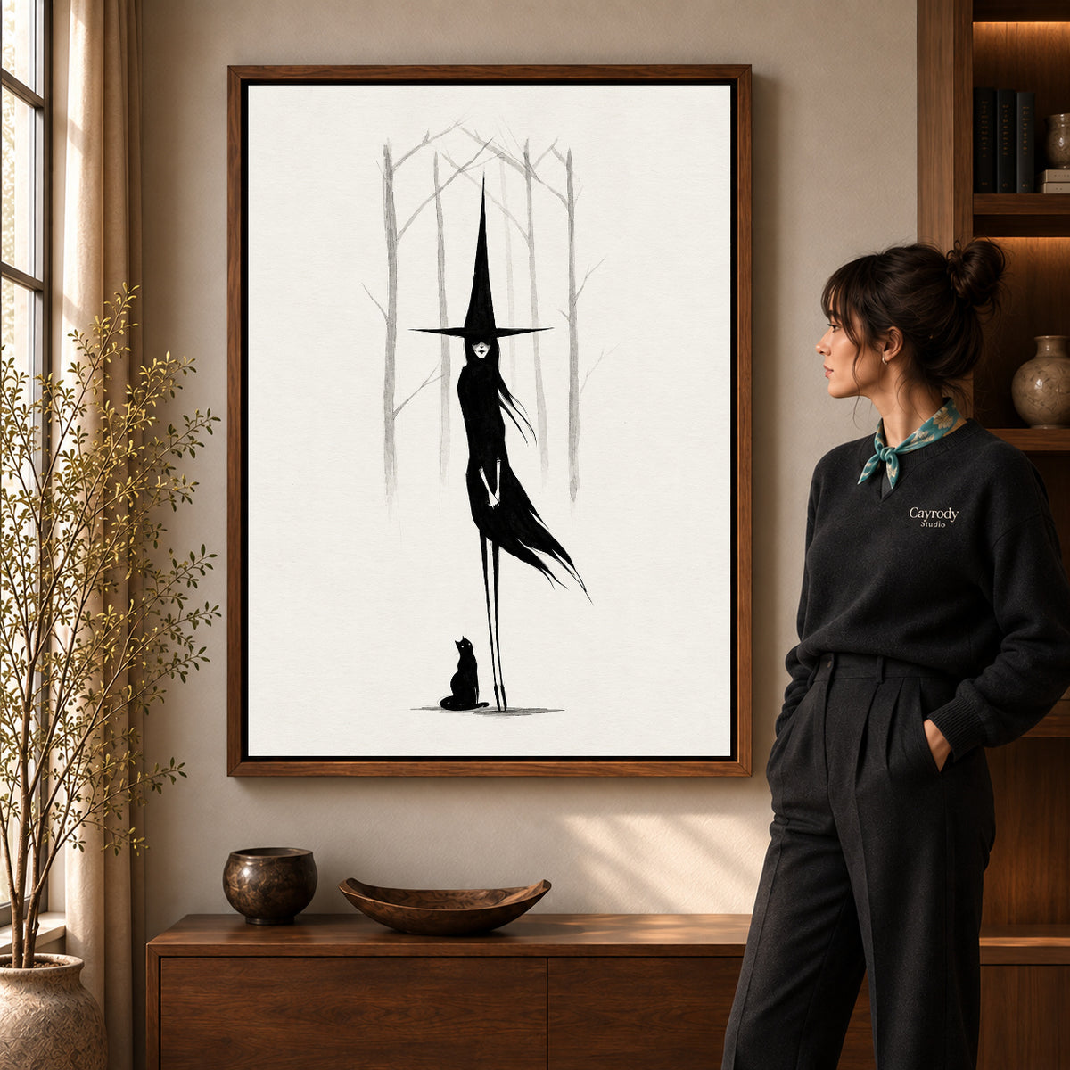 Tall Witch Companion artwork in a walnut frame beside a standing woman in a warm room.