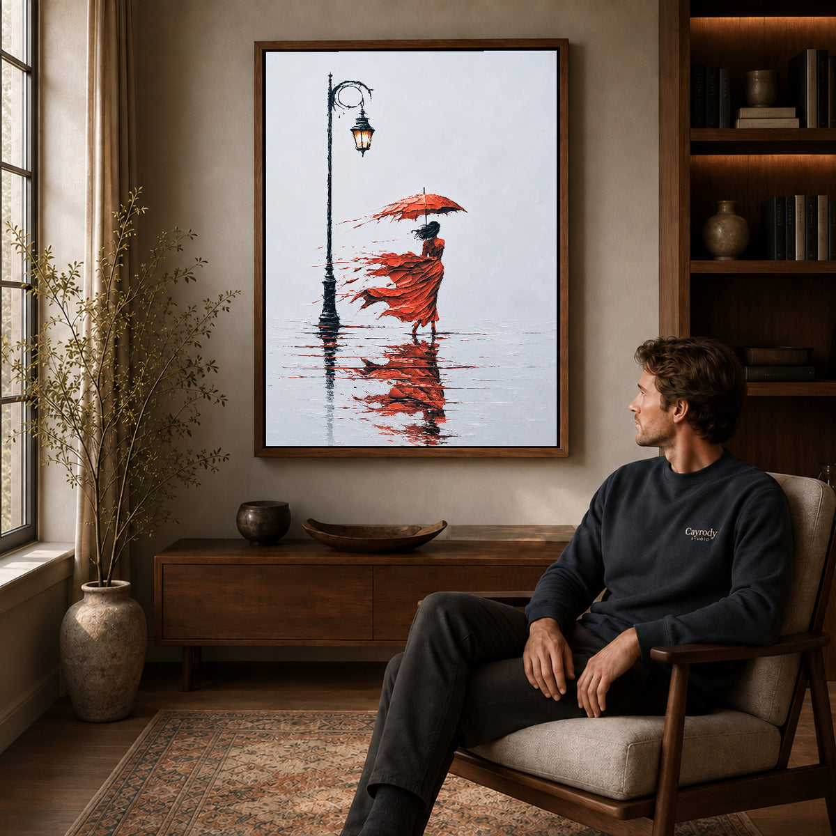 Walnut framed windy red umbrella artwork above a seated man in a wood furnished living room.