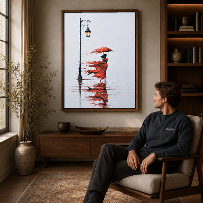 Walnut framed windy red umbrella artwork above a seated man in a wood furnished living room.