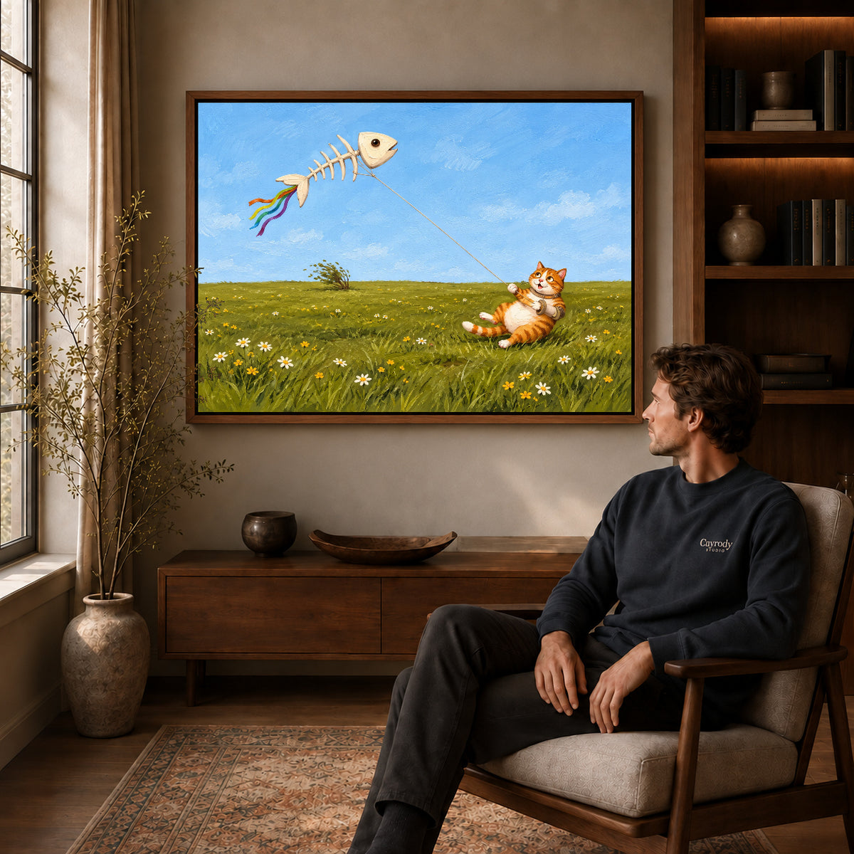 Walnut framed joyful kite cat artwork above a seated man in a wood furnished living room.