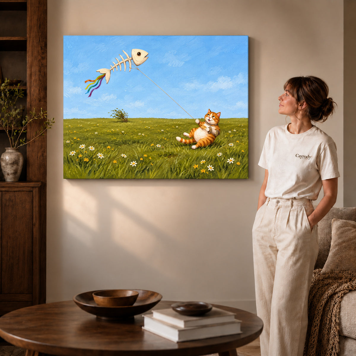 Gallery wrapped joyful kite cat artwork with shaded canvas edges beside a woman wearing cream clothing.