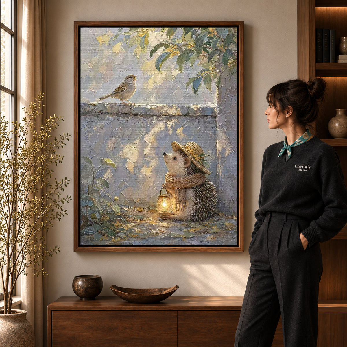 Hedgehog Lantern Walk artwork in a walnut frame beside a standing woman in a warm room.