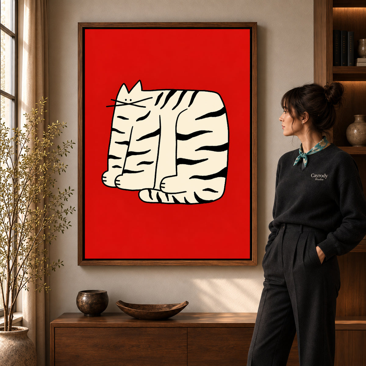 Bold Striped Cat artwork in a walnut frame beside a standing woman in a warm room.