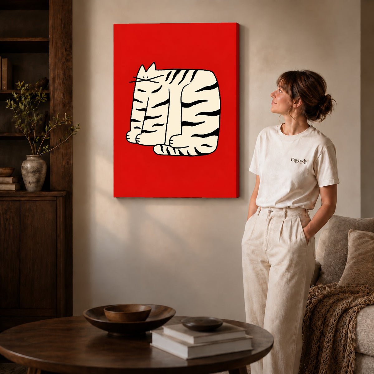 Gallery wrapped bold striped cat artwork with shaded canvas edges beside a woman wearing cream clothing.