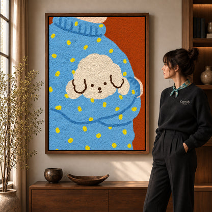 Cozy Puppy Sweater artwork in a walnut frame beside a standing woman in a warm room.