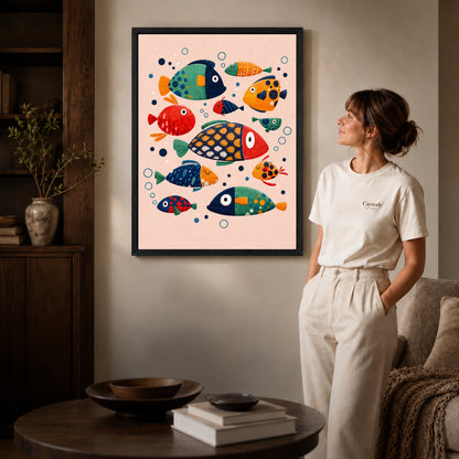 Black framed colorful folk fish artwork beside a woman in a warm neutral living room.