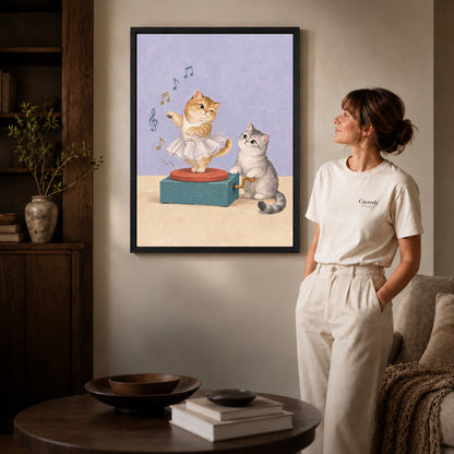 Black framed music box kittens artwork beside a woman in a warm neutral living room.