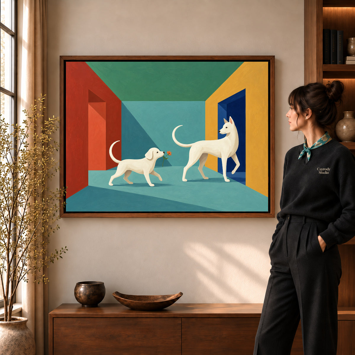 Flower Offering Dogs artwork in a walnut frame beside a standing woman in a warm room.