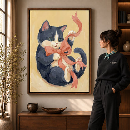 Ribbon Playing Kitten artwork in a walnut frame beside a standing woman in a warm room.