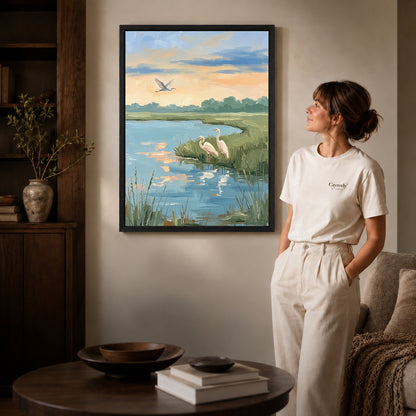 Black framed quiet marsh herons artwork beside a woman in a warm neutral living room.