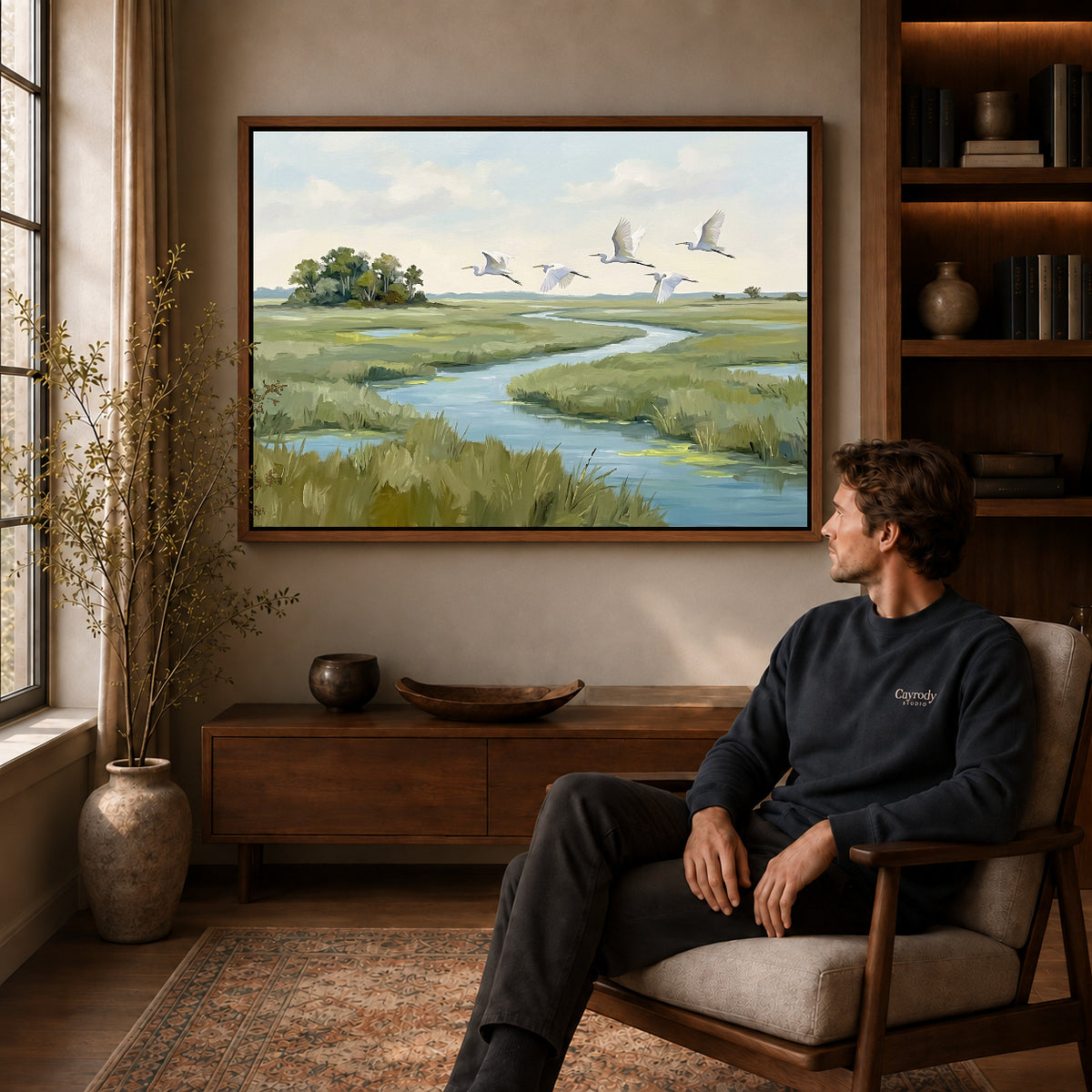 Walnut framed marsh bird flight artwork above a seated man in a wood furnished living room.