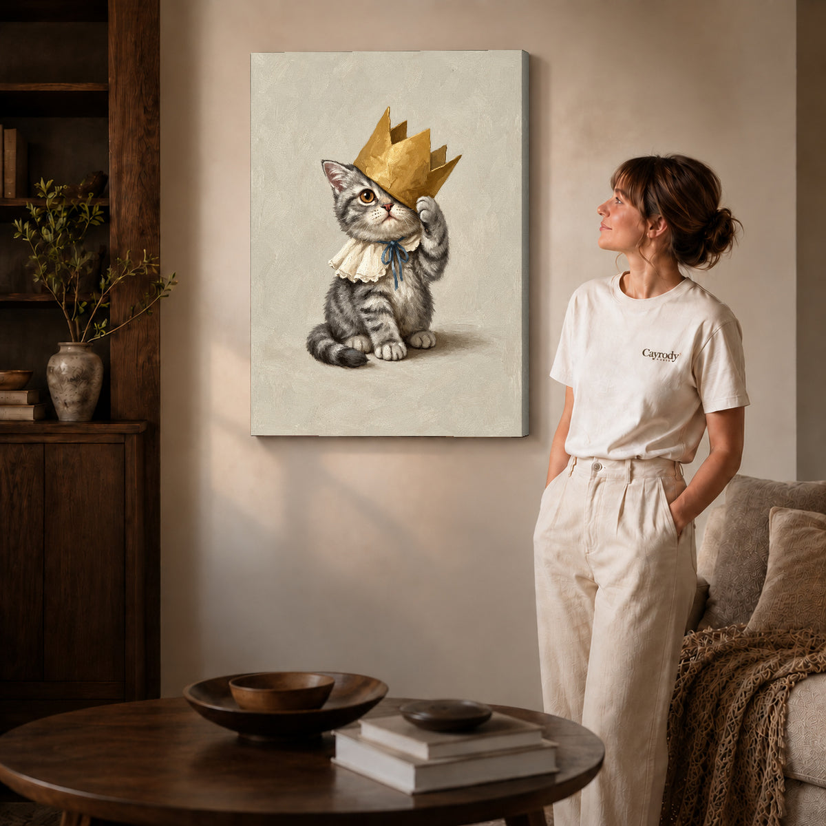 Gallery wrapped golden crown kitten artwork with shaded canvas edges beside a woman wearing cream clothing.