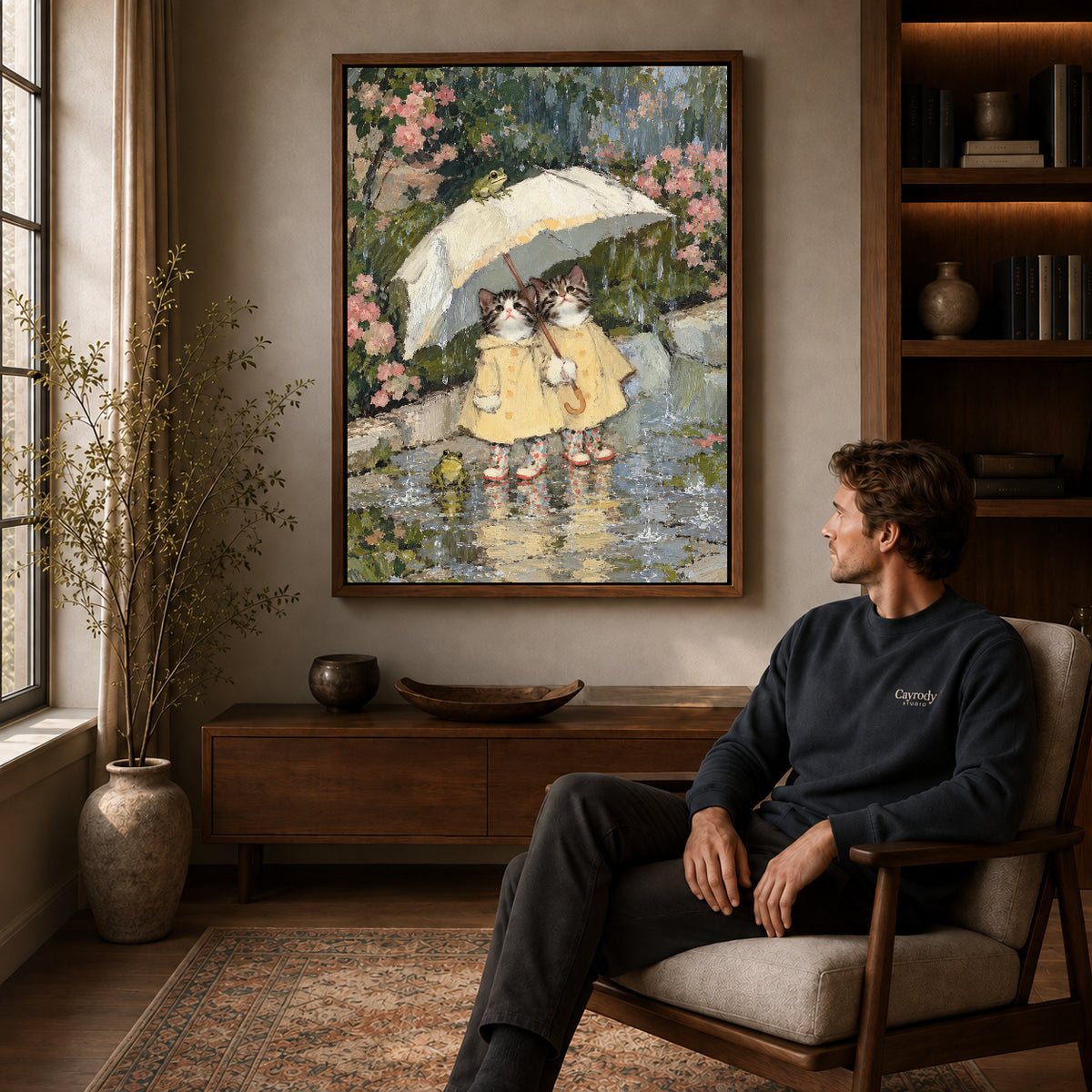 Walnut framed raincoat kitten friends artwork above a seated man in a wood furnished living room.