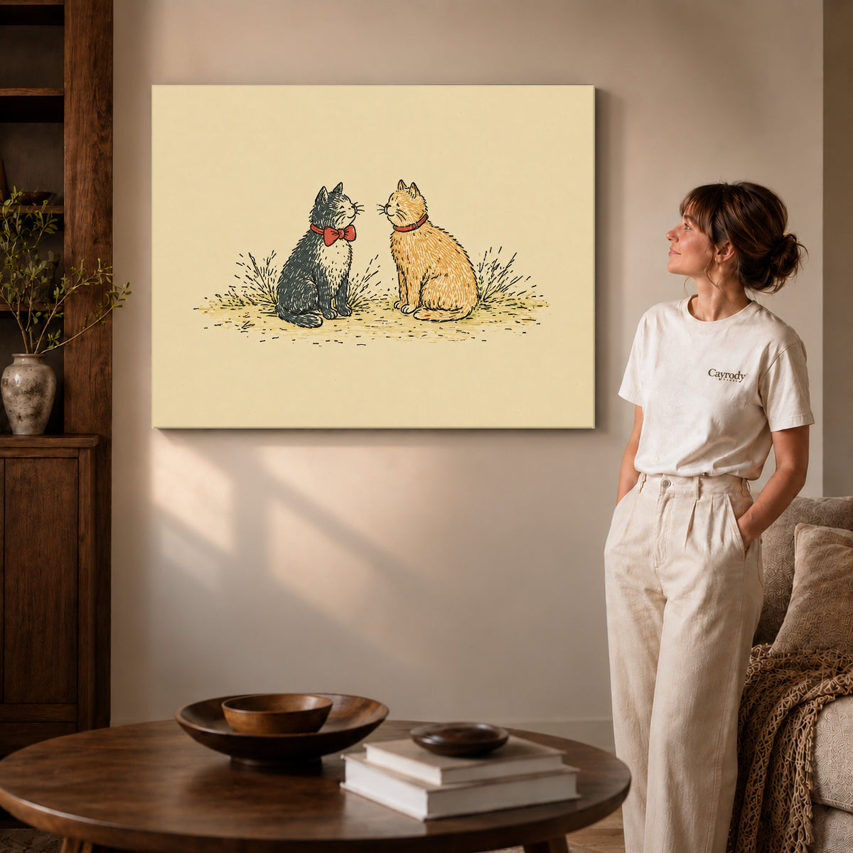 Gallery wrapped bow tie cat pair artwork with shaded canvas edges beside a woman wearing cream clothing.