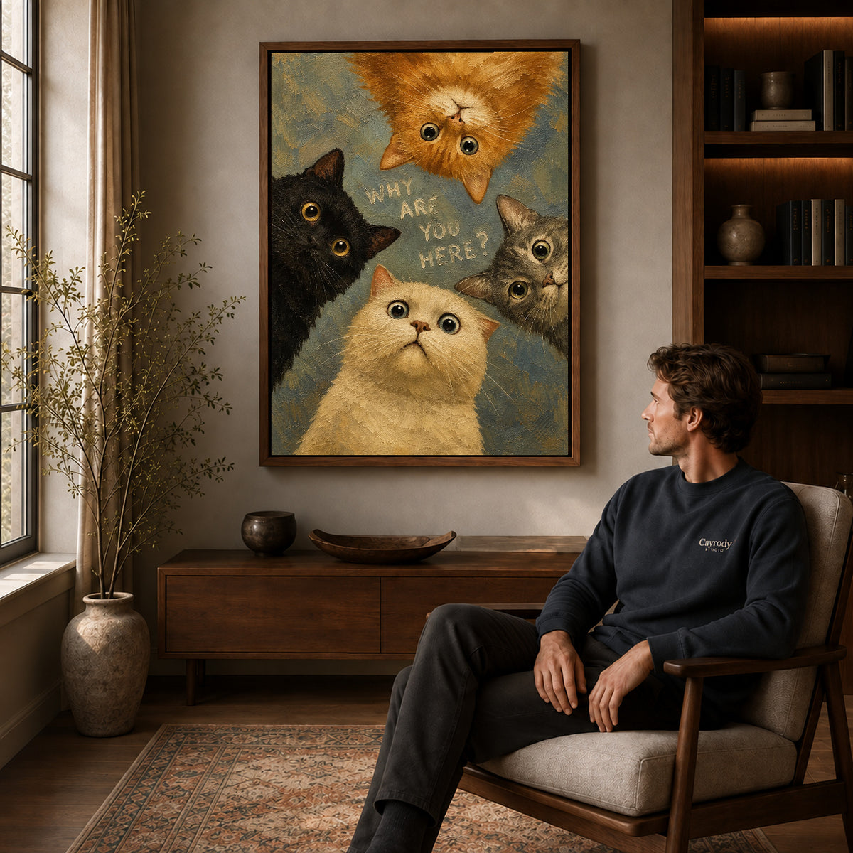 Walnut framed curious cat quartet artwork above a seated man in a wood furnished living room.