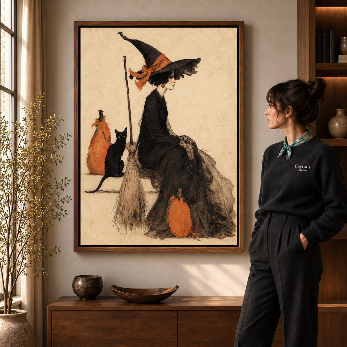 Elegant Witch Companion artwork in a walnut frame beside a standing woman in a warm room.