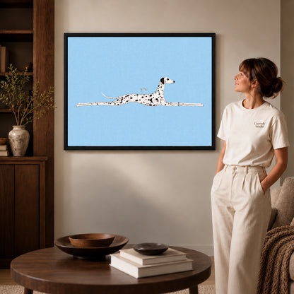 Black framed long dalmatian lounge artwork beside a woman in a warm neutral living room.