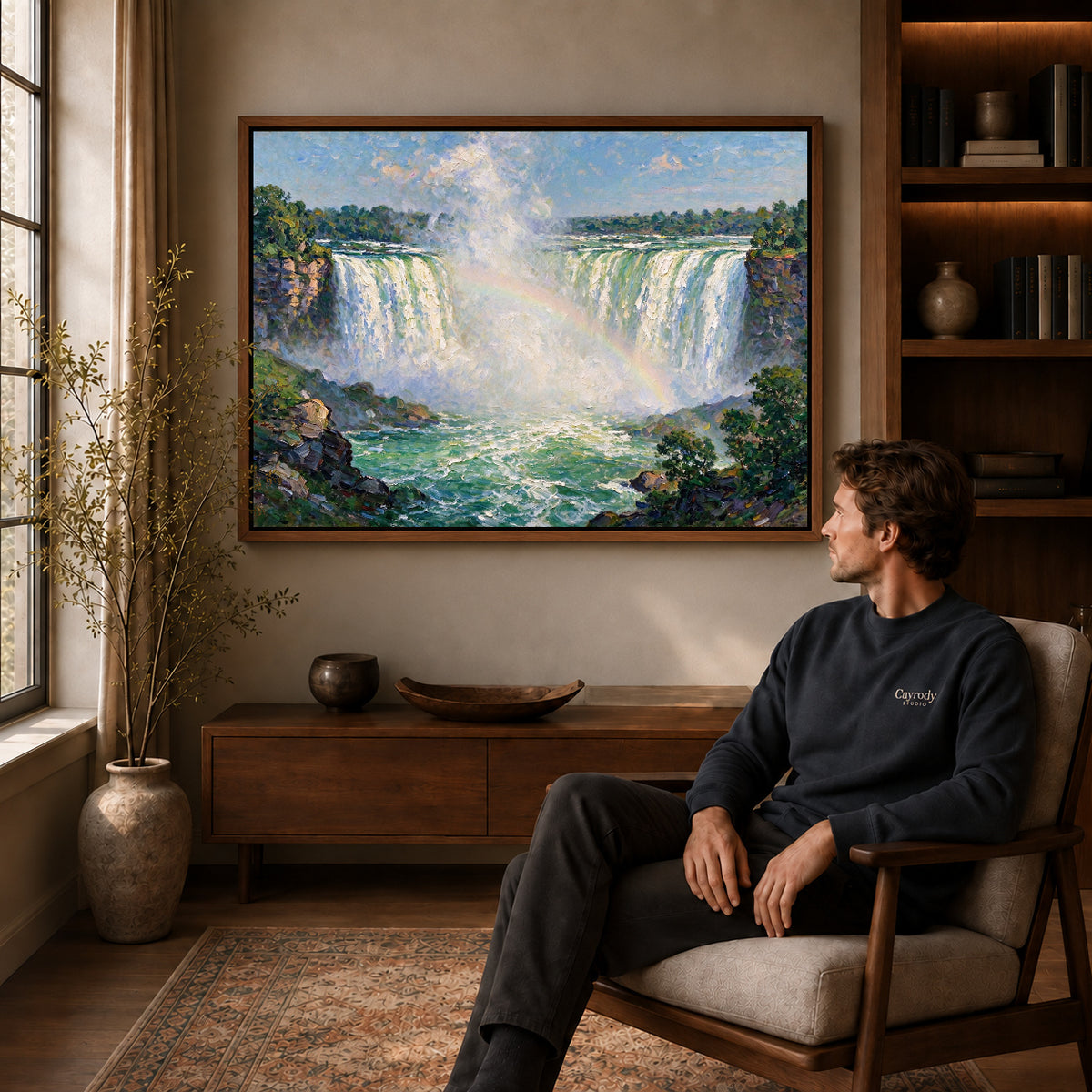 Walnut framed rainbow waterfall view artwork above a seated man in a wood furnished living room.