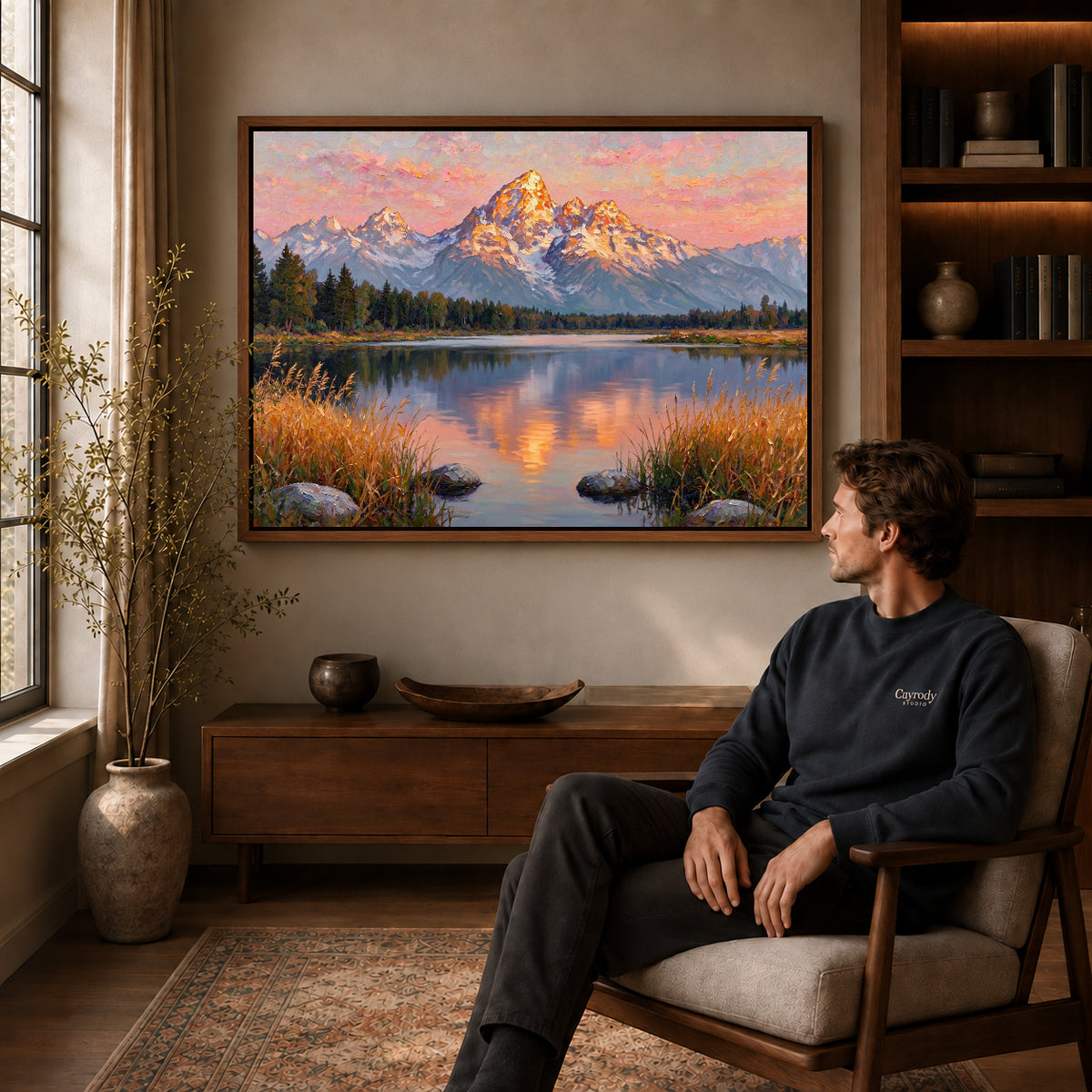 Walnut framed golden mountain reflection artwork above a seated man in a wood furnished living room.
