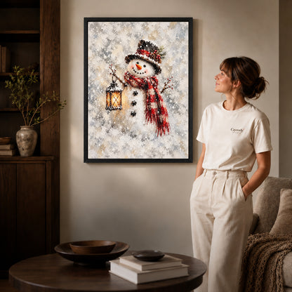 Black framed lantern snowman artwork beside a woman in a warm neutral living room.