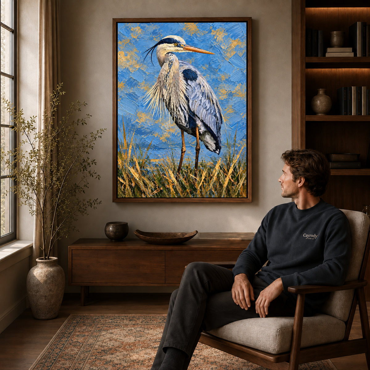 Walnut framed blue heron portrait artwork above a seated man in a wood furnished living room.