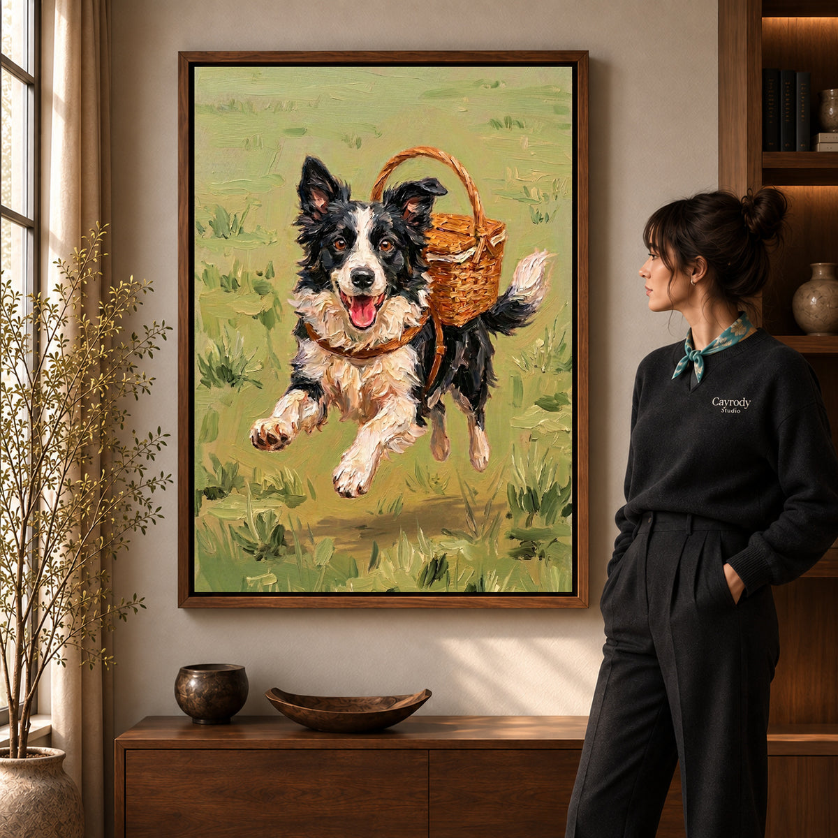 Basket Carrying Collie artwork in a walnut frame beside a standing woman in a warm room.