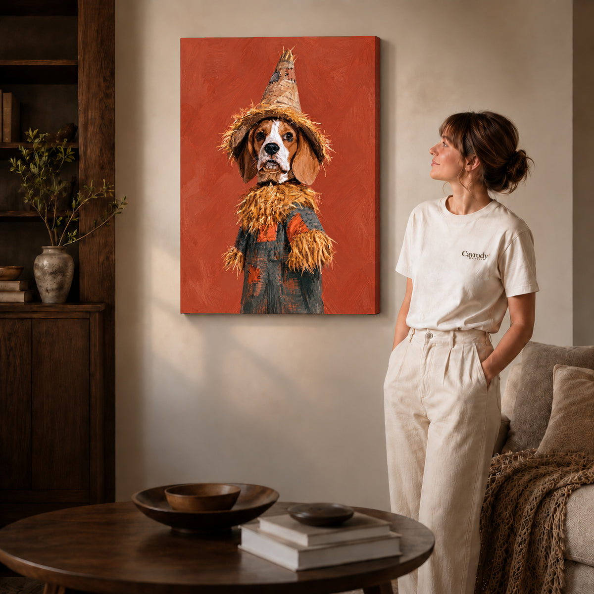 Gallery wrapped scarecrow spaniel artwork with shaded canvas edges beside a woman wearing cream clothing.