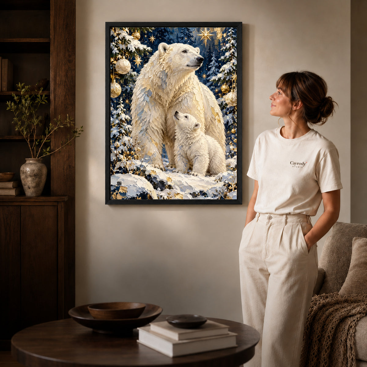 Black framed festive polar bear family artwork beside a woman in a warm neutral living room.