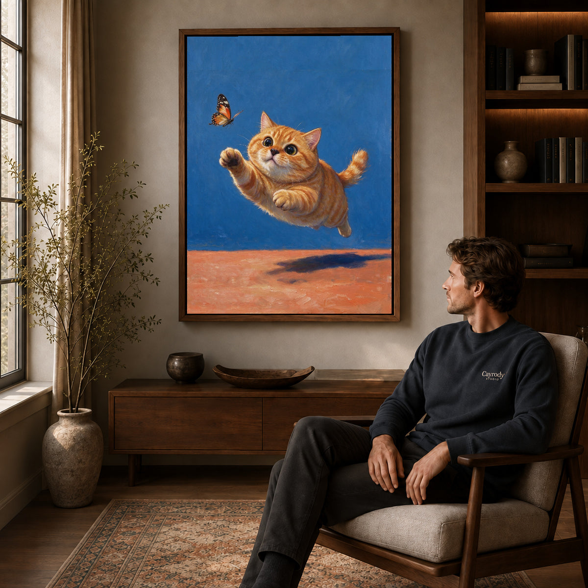 Walnut framed butterfly chasing kitten artwork above a seated man in a wood furnished living room.