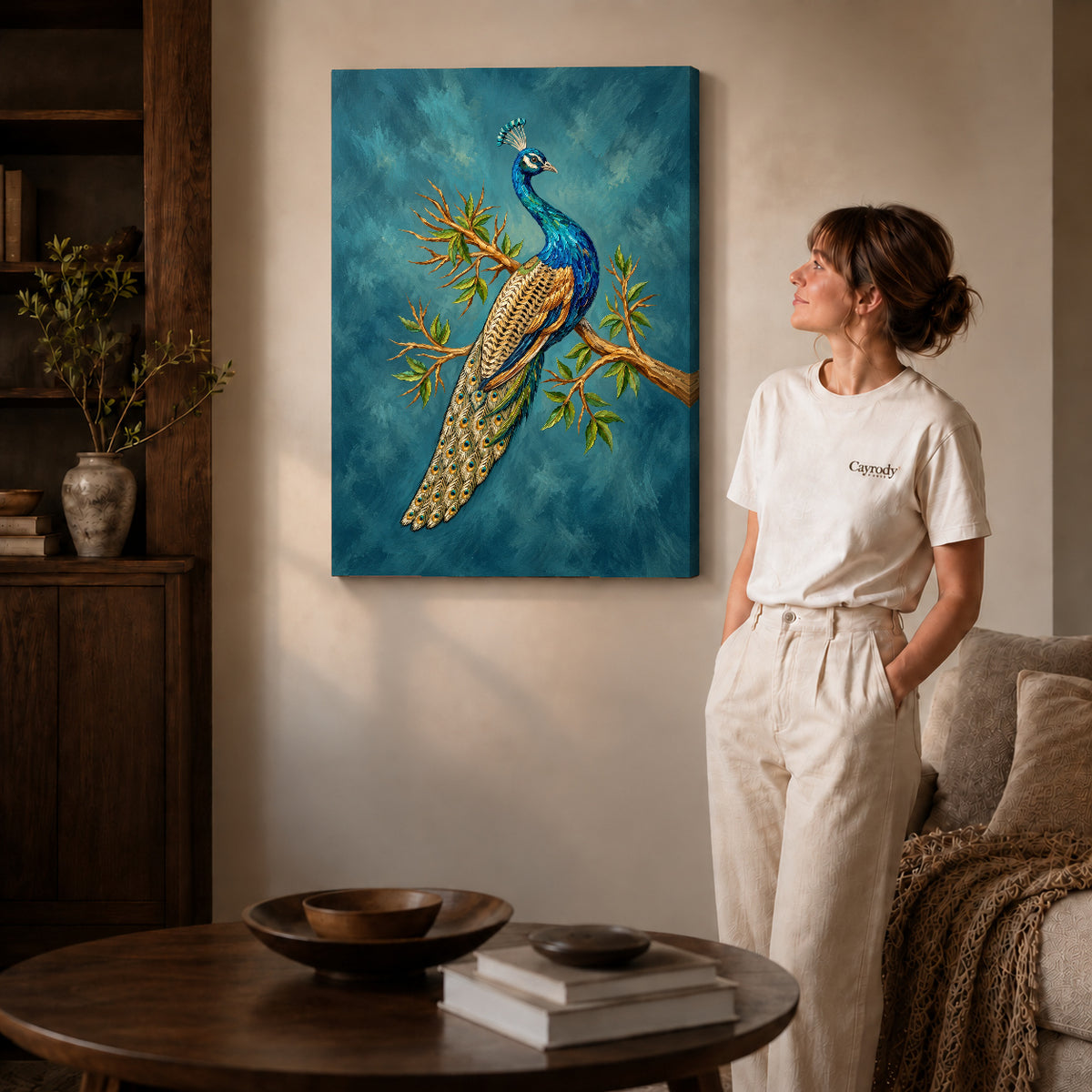 Gallery wrapped perched peacock artwork with shaded canvas edges beside a woman wearing cream clothing.