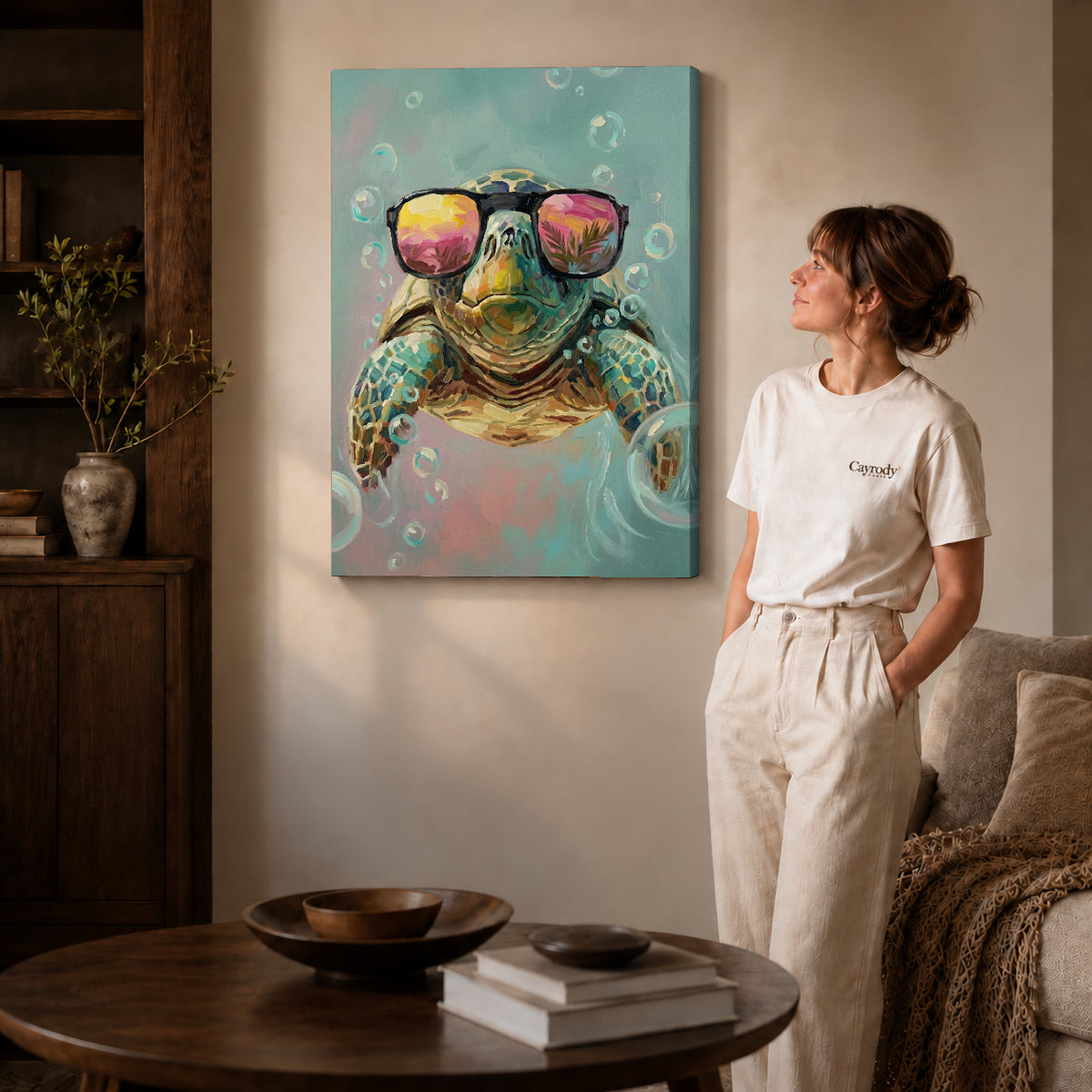 Gallery wrapped sunglasses sea turtle artwork with shaded canvas edges beside a woman wearing cream clothing.