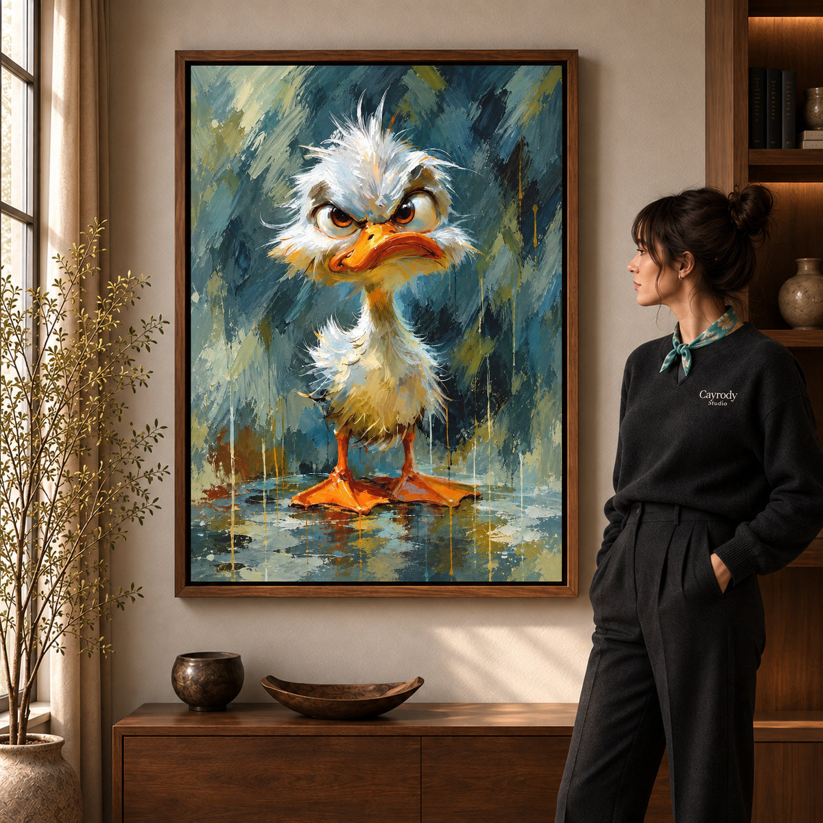 Grumpy Fluffy Duck artwork in a walnut frame beside a standing woman in a warm room.