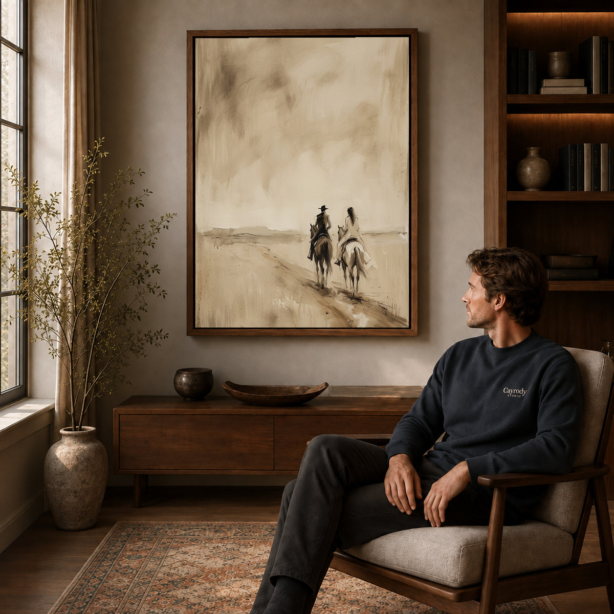 Walnut framed quiet western riders artwork above a seated man in a wood furnished living room.