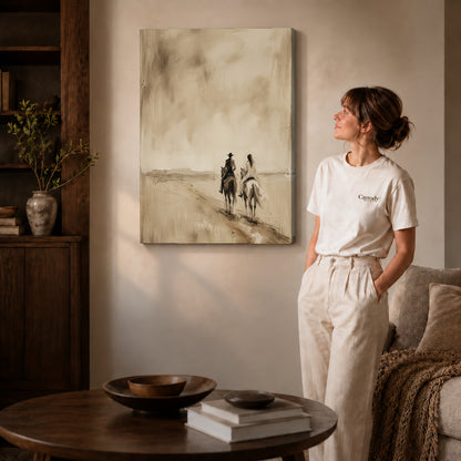 Gallery wrapped quiet western riders artwork with shaded canvas edges beside a woman wearing cream clothing.