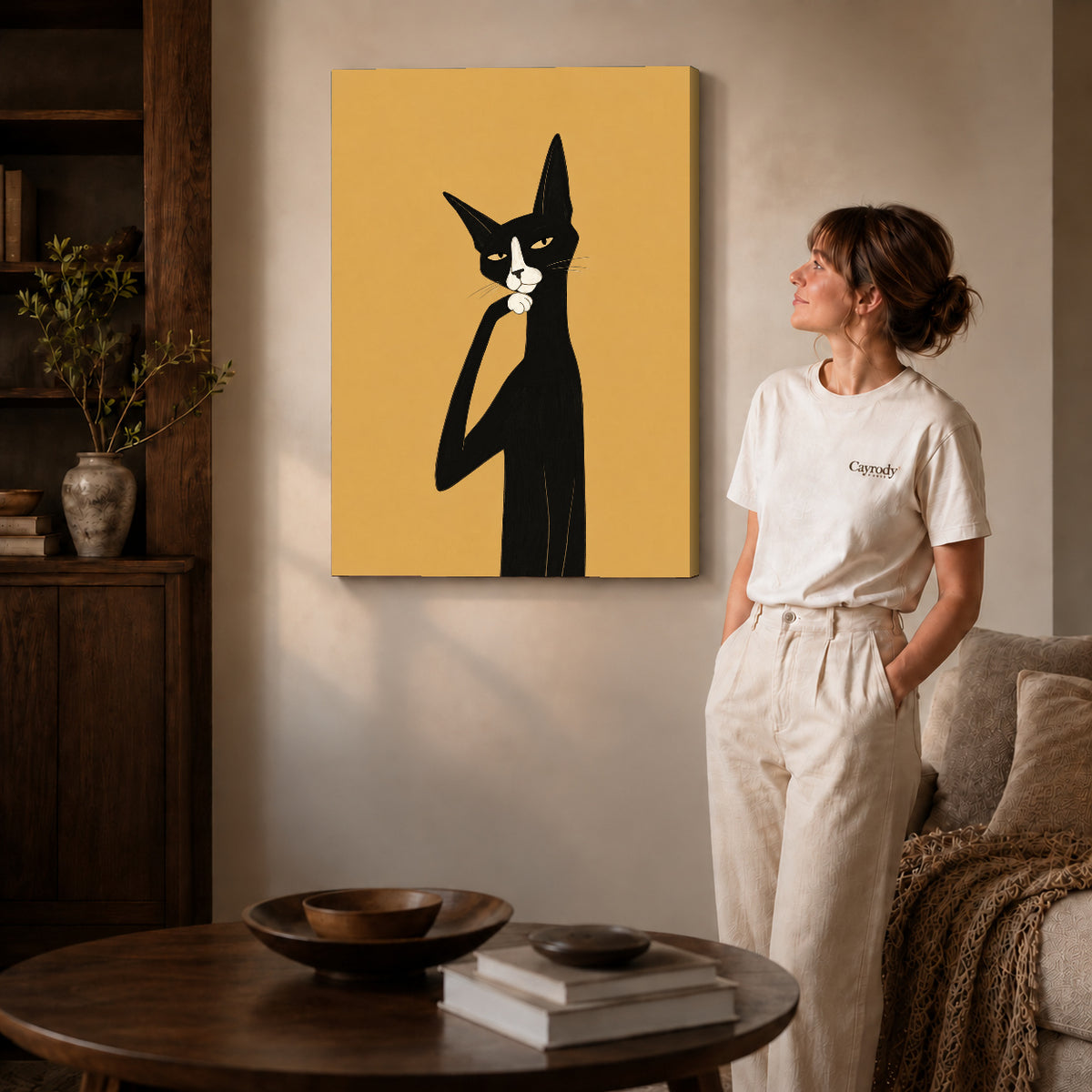 Gallery wrapped thoughtful tuxedo cat artwork with shaded canvas edges beside a woman wearing cream clothing.