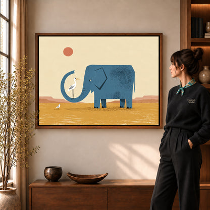 Elephant Bird Friends artwork in a walnut frame beside a standing woman in a warm room.