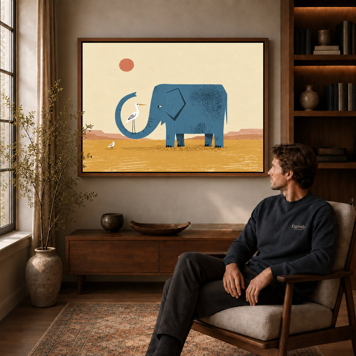 Walnut framed elephant bird friends artwork above a seated man in a wood furnished living room.