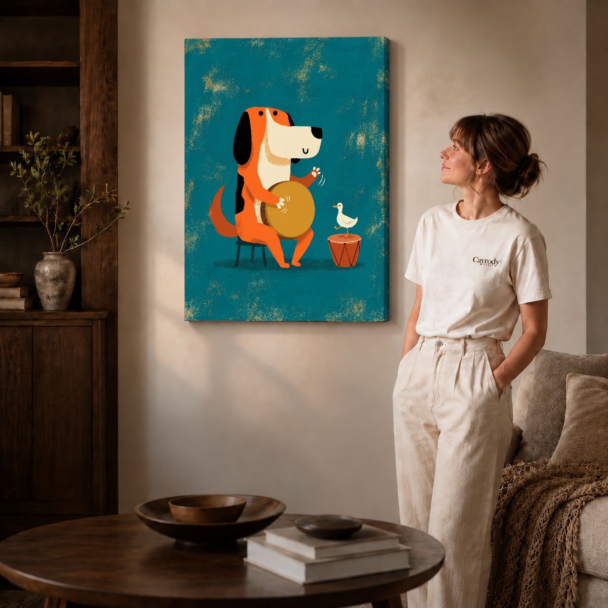 Gallery wrapped drumming dog duo artwork with shaded canvas edges beside a woman wearing cream clothing.