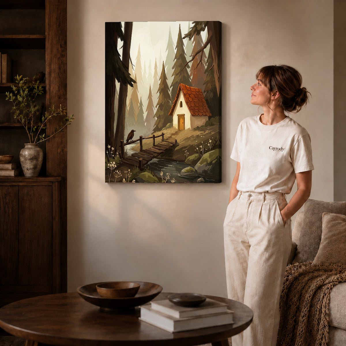 Gallery wrapped quiet forest cottage artwork with shaded canvas edges beside a woman wearing cream clothing.